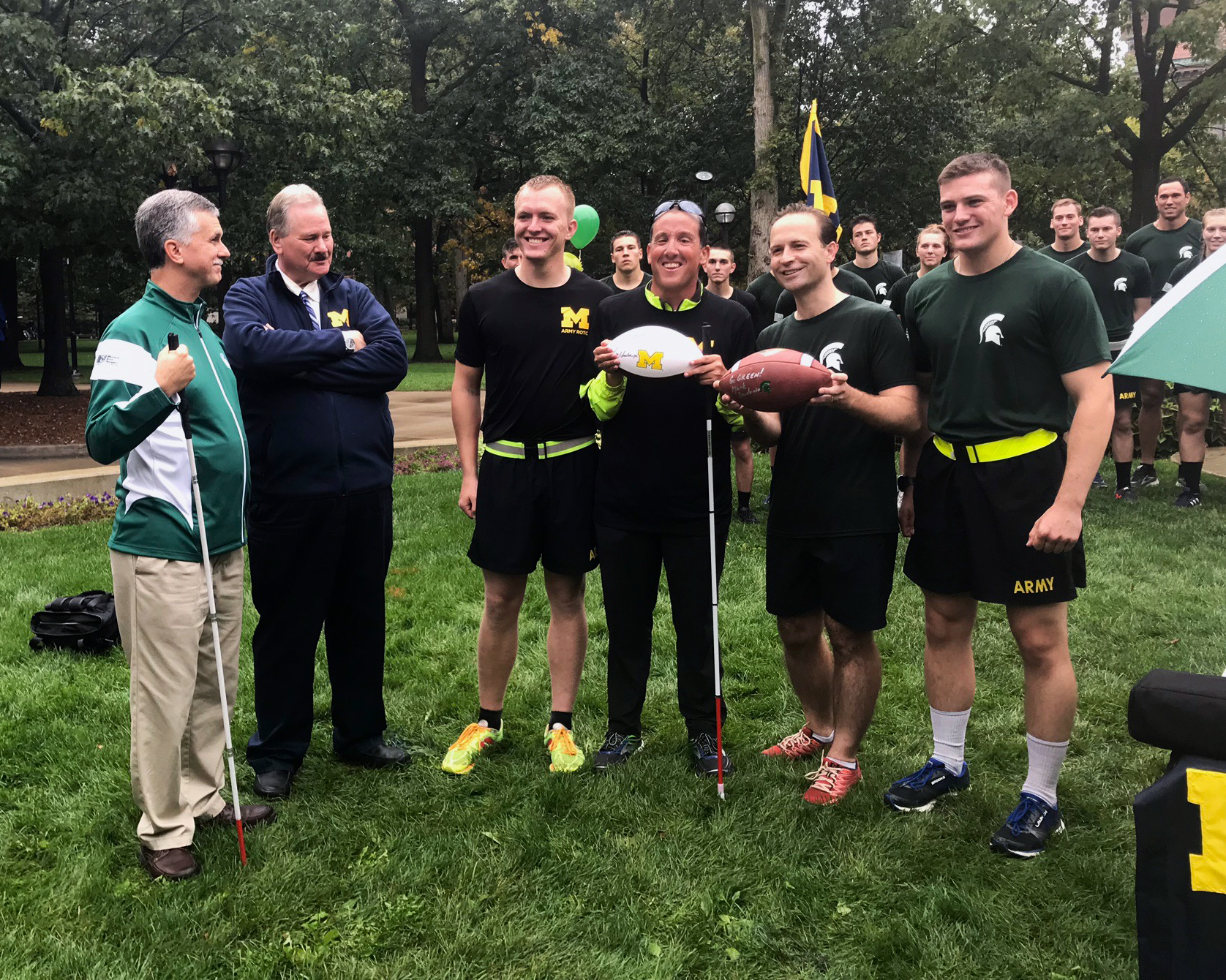 University of Michigan and Michigan State University members holding the football pre-game