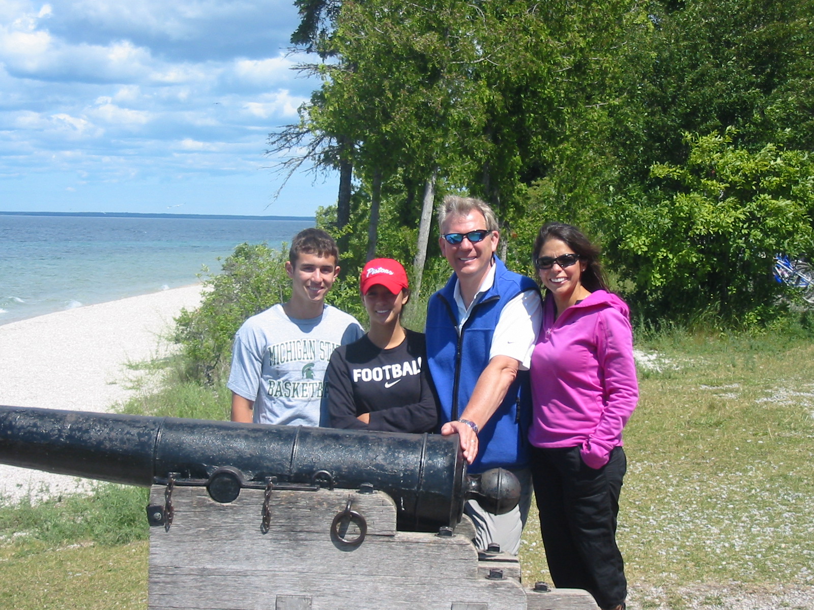 The Powell family posing in front of a historic cannon