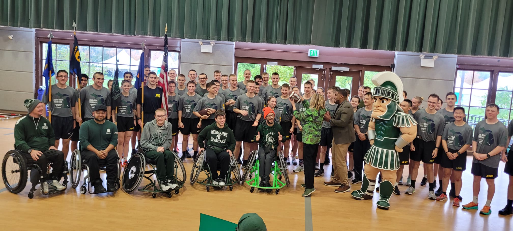 a large group photo of all runners and rollers along with Theresa Woodruff, Interim MSU President and Sparty