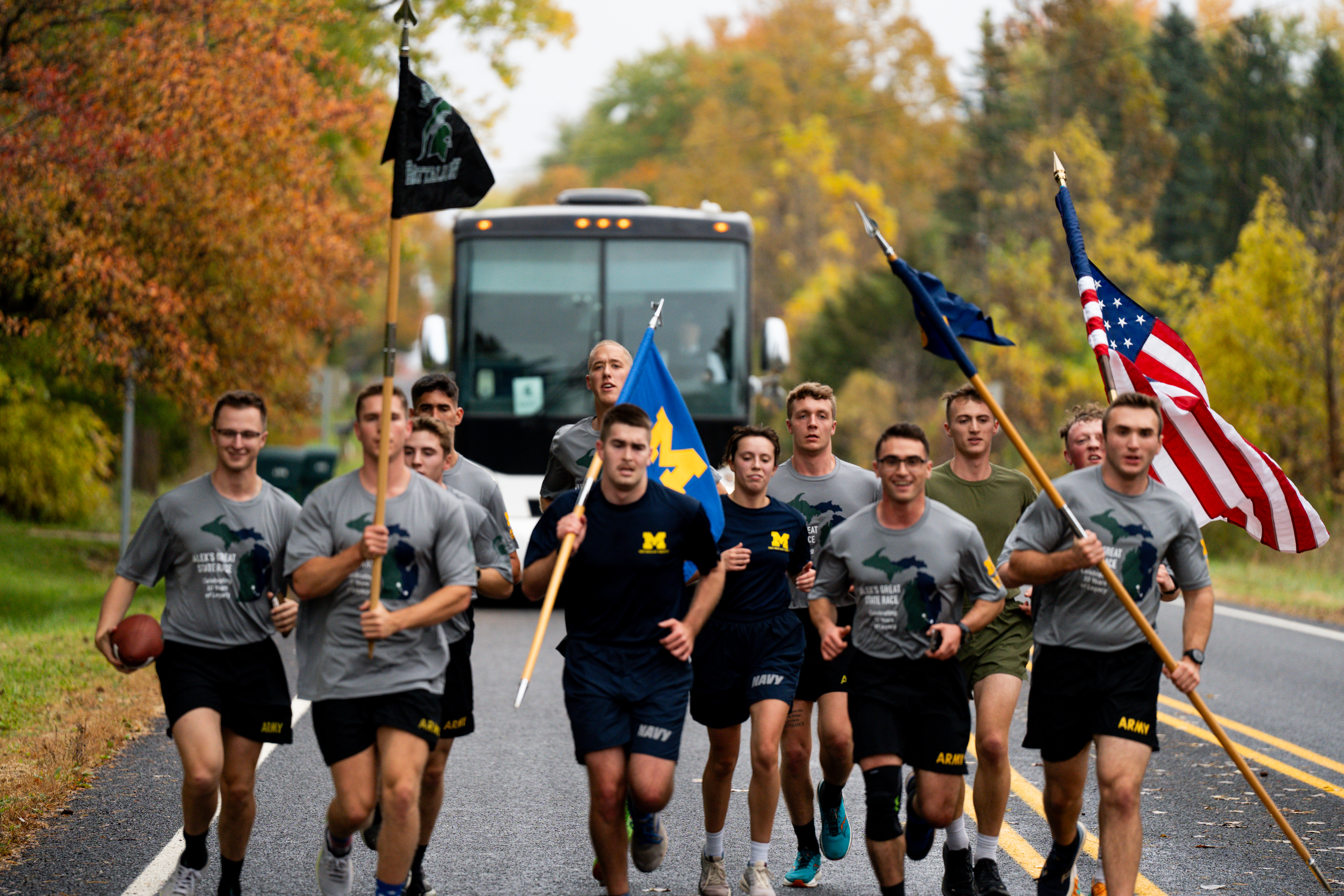 Cadets running in front of AGSR bus carrying the US flag