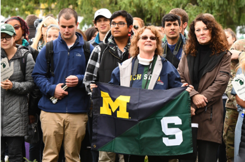 Alex's Great State Race Spectators holding a UM/MSU Flag in support