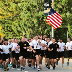 A team of football players running together with an American flag