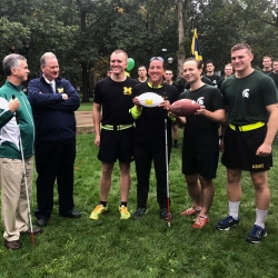 University of Michigan and Michigan State University members holding the football pre-game