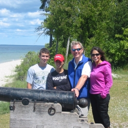 The Powell family posing in front of a historic cannon