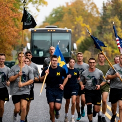 Cadets running in front of AGSR bus carrying the US flag