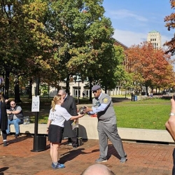 ROTC cadet presenting official game ball to Martino Harmon, VP of Student Affairs at UM